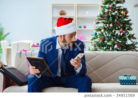 Businessman working at home during christmas Businessman working at home during christmas 34951569