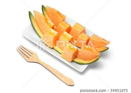 Sliced orange melon in pieces on a white plate. Sliced orange melon in pieces on a white plate. 34951875