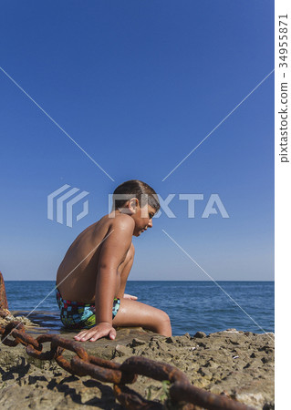 wet boy sit on pier 34955871