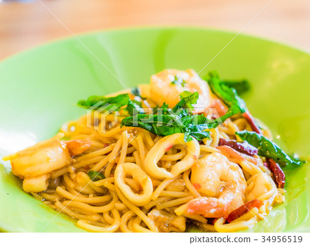 Spicy Spaghetti Seafood in a green plate on wooden 34956519