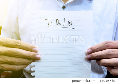man in white shirt hold paper to do list man in white shirt hold paper to do list 34956710
