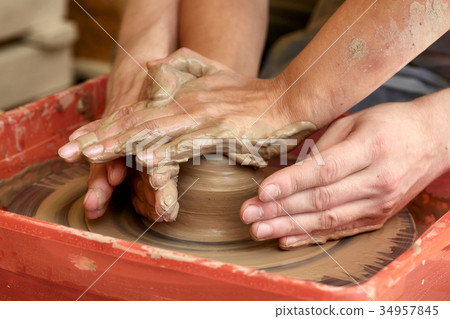 Hands of two people create pot, potter's wheel Hands of two people create pot, potter's wheel 34957845