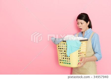 young female maid worker holding laundry basket young female maid worker holding laundry basket 34957940