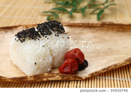 芝麻飯糰和醃製的李子在竹皮上 芝麻飯糰和醃製的李子在竹皮上 34958740
