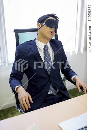在衣服佩帶的眼罩和休假的年輕銷售商人在公司辦公室 34959872