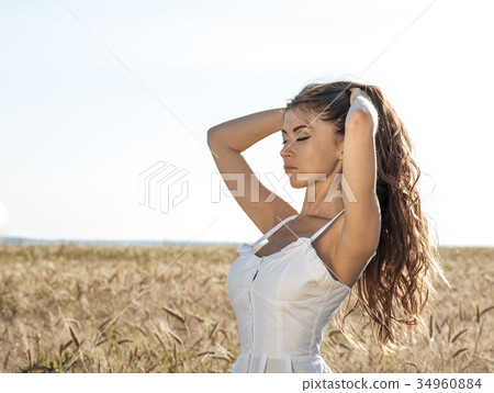 Beautiful summer girl in a wheat field, in a white Beautiful summer girl in a wheat field, in a white 34960884