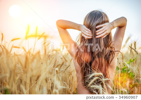 A girl in the field adjusts her hair, a naked A girl in the field adjusts her hair, a naked 34960907