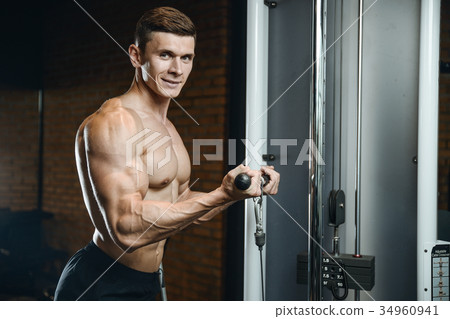 Handsome model young man training arms in gym 34960941