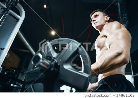 Handsome model young man training arms in gym 34961102