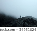 Mountain climber walking in the clouds 34961824