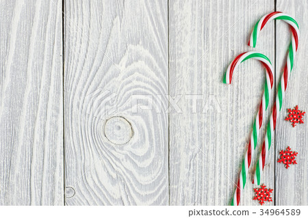 Christmas cane decoration on wooden background Christmas cane decoration on wooden background 34964589