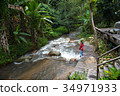 Woman tourism standing on little waterfall,stream 34971933