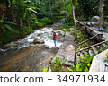 Woman tourism standing on little waterfall,stream 34971934