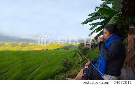 Woman tourism sitting on wood balcony drink coffee 34972011
