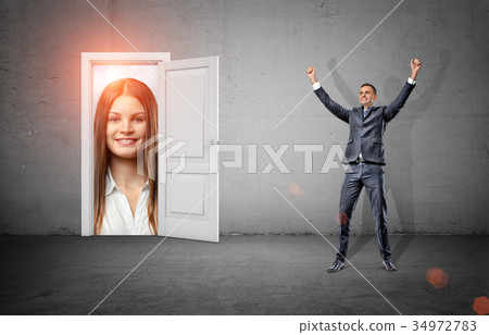 A happy businessman in victory motion stands in a 34972783