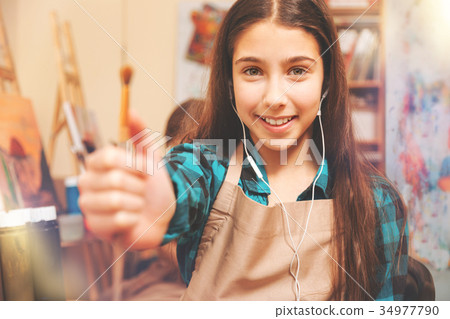 Charming teenage lady with headphones showing Charming teenage lady with headphones showing 34977790