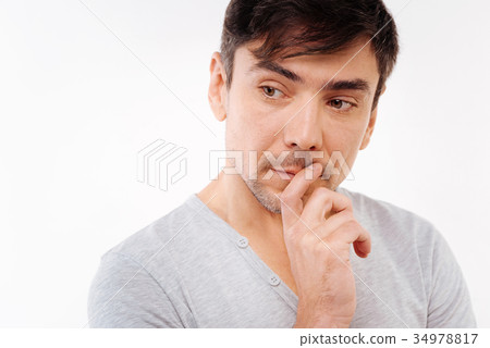 Handsome dark-haired man pondering something Handsome dark-haired man pondering something 34978817