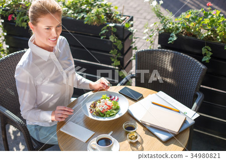 Smiling woman being about to eat Greek salad Smiling woman being about to eat Greek salad 34980821