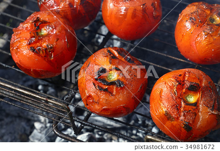 Red tomatoes cooked on bbq grill close up Red tomatoes cooked on bbq grill close up 34981672