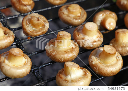White champignons mushrooms on grill 34981673