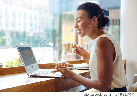 Young woman checking the application and drinking 34981747