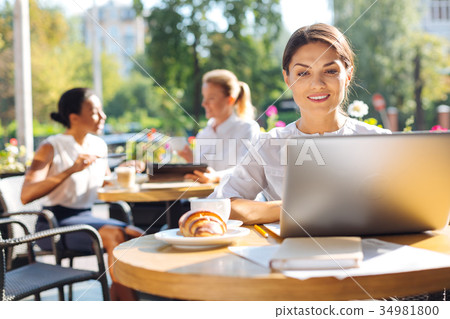 Smiling woman working on her project in cafe 34981800