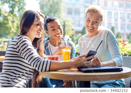 Charming friends taking a selfie together in cafe 34982152