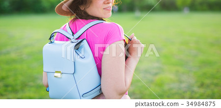 Young female with blue backpack and hat enjoying Young female with blue backpack and hat enjoying 34984875