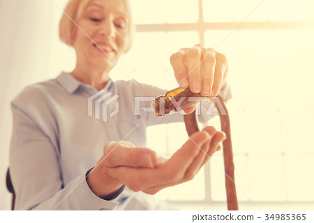 Close up of a positive aged woman taking pills 34985365