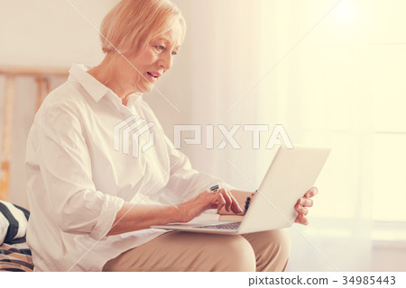 Pleasant senior woman using her laptop at home 34985443