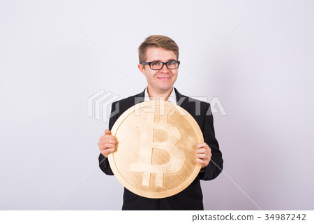 Happy cheerful young businessman holding big Happy cheerful young businessman holding big 34987242