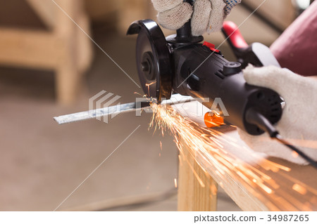 Heavy industry worker cutting steel with angle Heavy industry worker cutting steel with angle 34987265