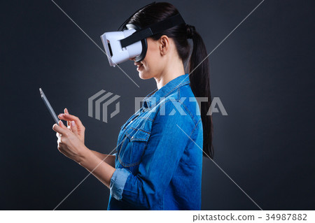 Cheerful positive woman using electronic device 34987882