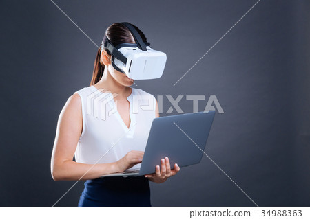 Smart nice businesswoman working on a laptop Smart nice businesswoman working on a laptop 34988363