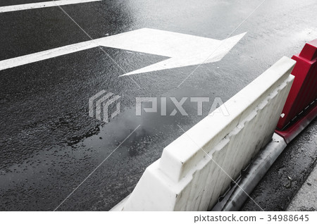 Wet urban street with arrow road marking 34988645