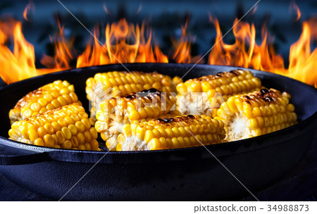 Frying pan with fried corn on fire background 34988873