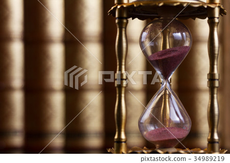 Hourglass with law books in background Hourglass with law books in background 34989219
