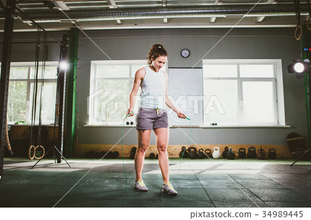 Young Caucasian smiling woman holding a skipping rope - Health and Fitness Concept Young Caucasian smiling woman holding a skipping rope - Health and Fitness Concept 34989445