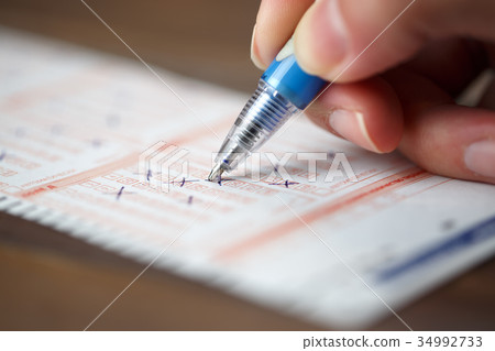Image of person marking in lottery ticket Image of person marking in lottery ticket 34992733