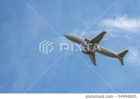 An airliner gliding over the blue sky 34998095