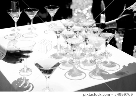 Man pours champagne in wineglasses 34999769