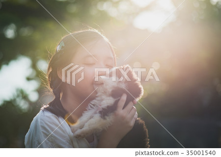 asian girl playing with siberian husky puppy  35001540