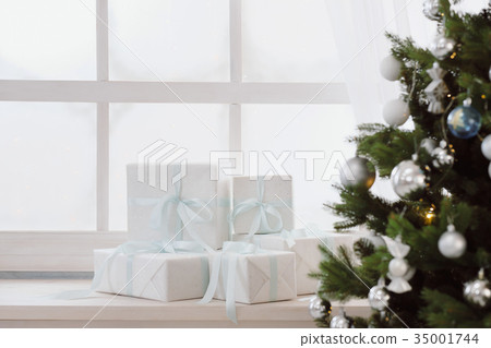 Christmas presents in white boxes on a window 35001744
