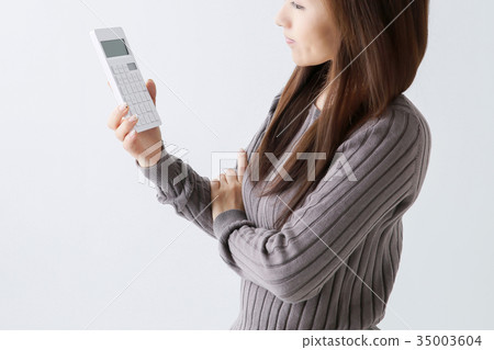 Woman operating a calculator 35003604