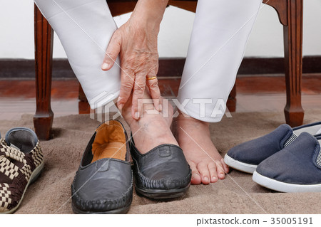 Elderly woman putting on shoes wrong feet Elderly woman putting on shoes wrong feet 35005191