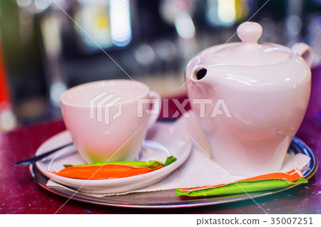 white ceramic kettle and a white mug on a saucer 35007251