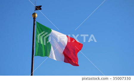 Waving big Italian flag against blue cloudless sky 35007330