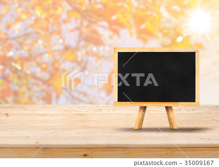 Blackboard with easel on wood table top with maple Blackboard with easel on wood table top with maple 35009167