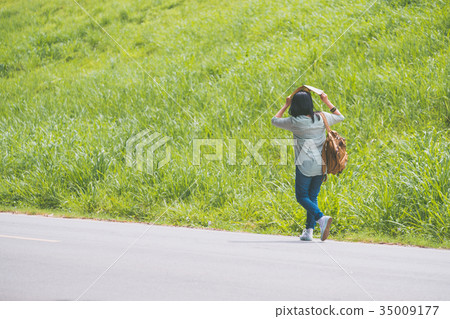 Asian traveler with backpack walking on road 35009177