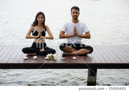 Happy couple doing yoga on jetty Happy couple doing yoga on jetty 35009485